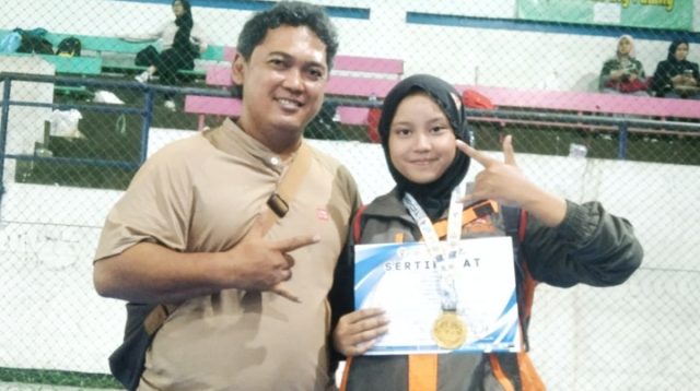 Tasya Syarifatussakhi berfoto bersama Pelatih Kepala IPSI Kota Tasikmalaya, Farid Hermawan, usai meraih prestasi membanggakan dalam seleksi Popwilda Jawa Barat di GGM Kota Tasikmalaya, Rabu (20/5/2026). Siswi SMAN 3 Kota Tasikmalaya tersebut sukses meraih juara pertama kategori tanding dan peringkat ketiga jurus tunggal.