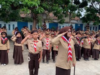 Mabigus SDN 2 Siluman, Iis Suhartini, S.Pd., memimpin penghormatan dalam upacara HUT Gerakan Pramuka ke-65 bersama ratusan anggota Pramuka Siaga dan Penggalang, Jumat (14/8/2026). Foto. Dok. Asep M